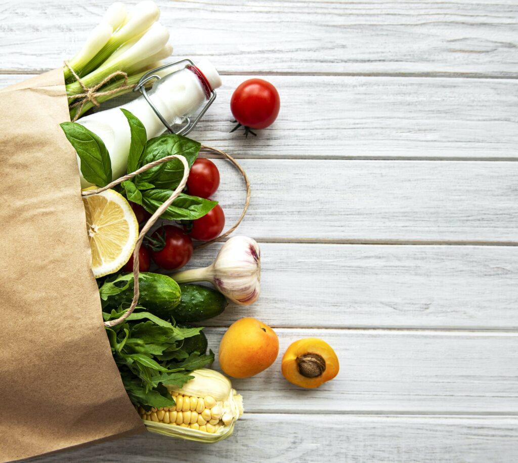 Healthy food background. Healthy food in paper bag, vegetables and fruits.